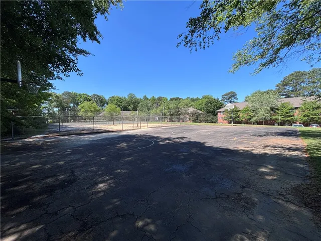 A versatile court area, ideal for community recreation, set against a backdrop of mature trees and residential buildings.