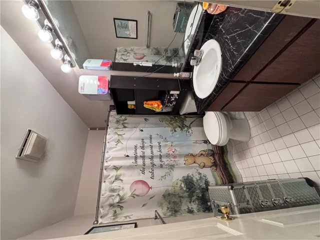 A well-appointed bathroom features a single vanity with a marble countertop and convenient storage.