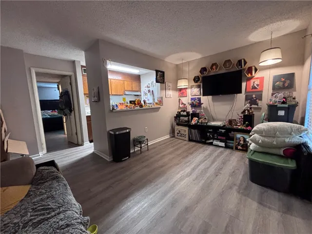 Step into a sun-filled living space featuring durable flooring and an open-concept layout connecting to the kitchen.