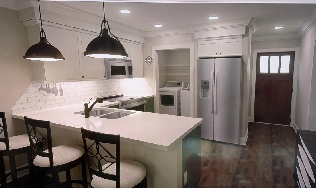 A well-appointed kitchen features a central island, ample cabinetry, and integrated laundry appliances.