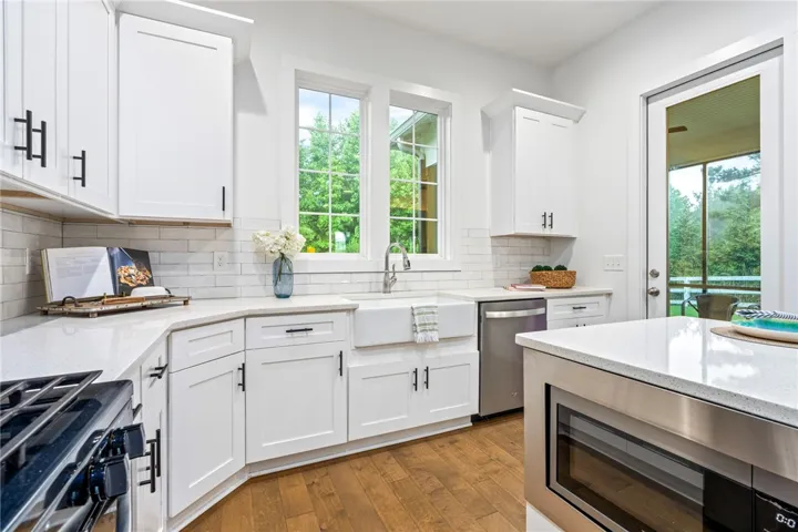 Farmhouse sink overlooks the wooded backyard.