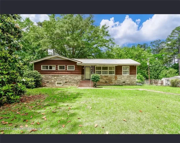 A charming exterior combines wood siding and natural stone for inviting curb appeal.