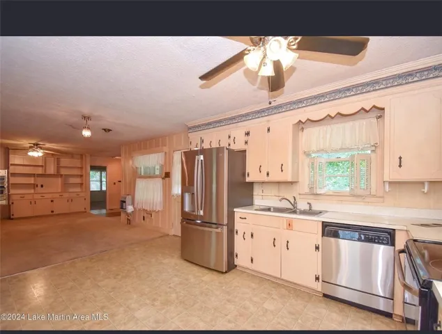 A well-appointed kitchen offers functional appliances and direct views into an adjacent living space with built-in shelving.