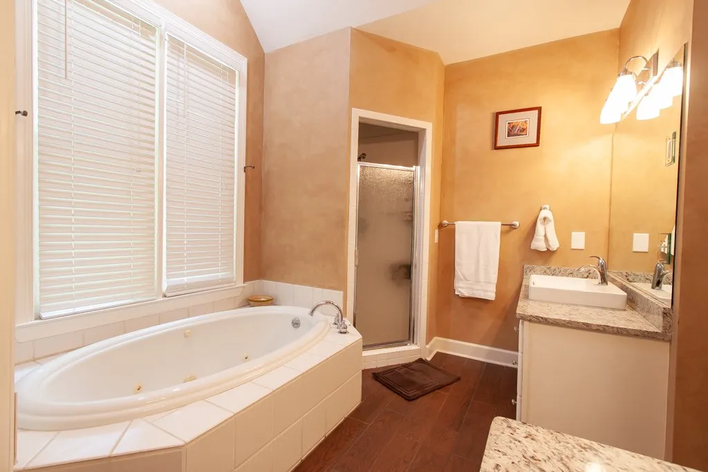 Indulge in a tranquil retreat featuring a deep soaking tub, a separate shower, and a vanity with abundant counter space.