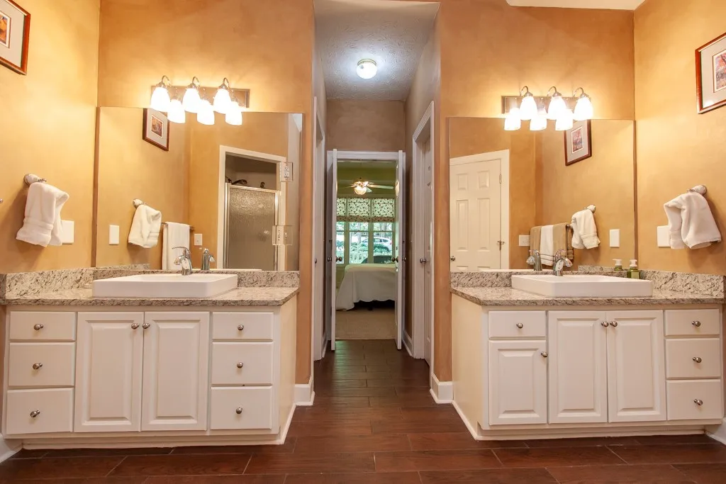 Dual vanities with granite counters provide ample space in this well-appointed primary bathroom.
