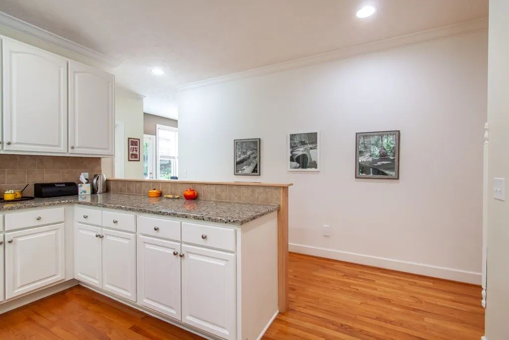 A well-lit kitchen with sleek cabinetry and natural wood flooring.