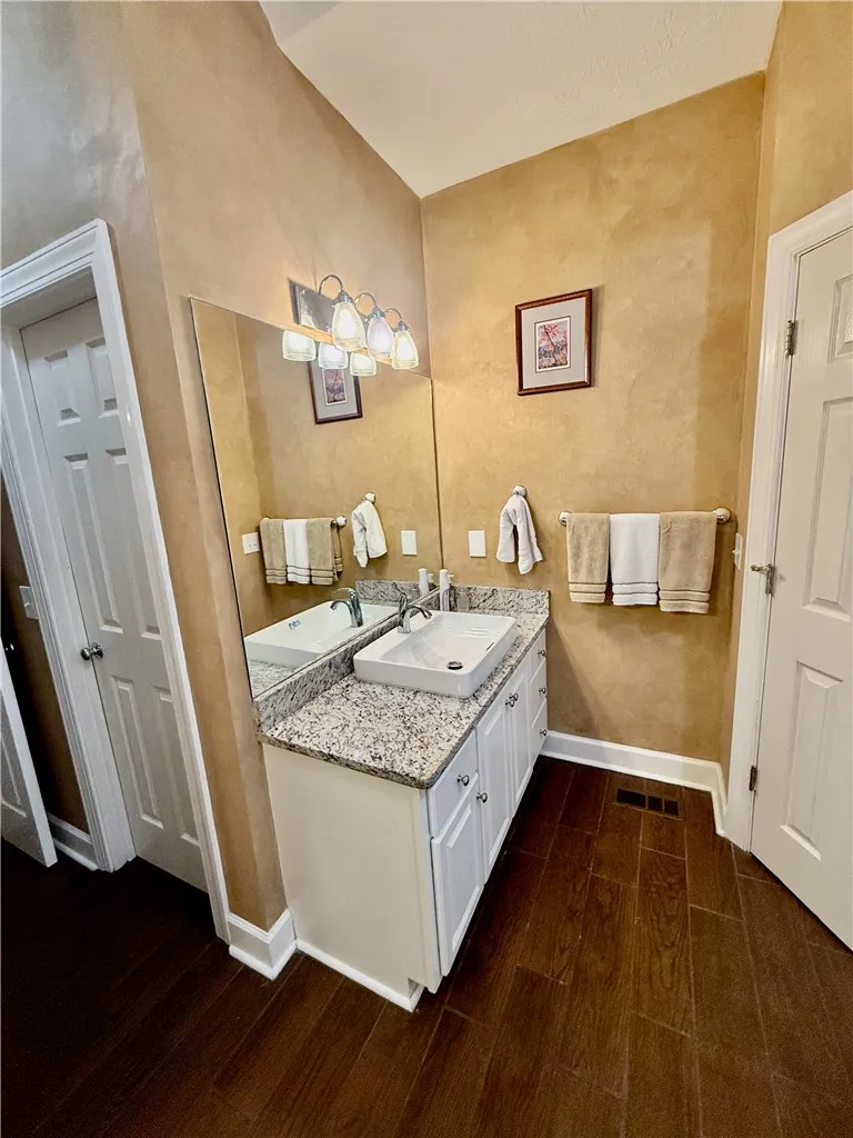 A refined bathroom featuring a contemporary vessel sink and granite counters.