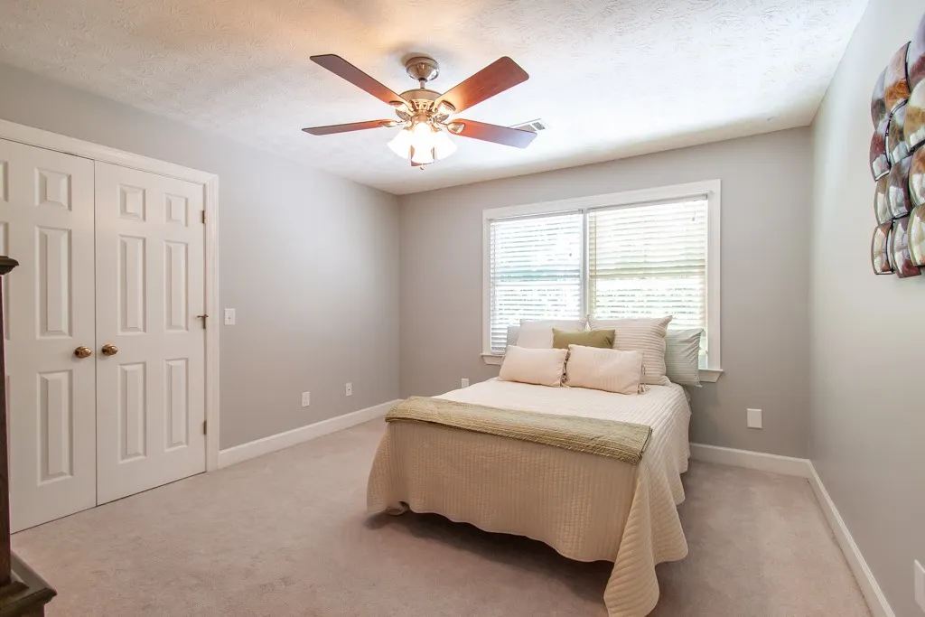 Bedroom 2-  Great closet space. A comfortable bedroom with a window offering natural illumination and a ceiling fan for cooling comfort.