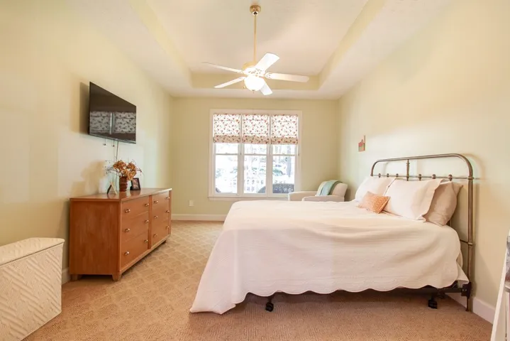 Recessed ceiling and ample natural light define this cozy bedroom retreat.