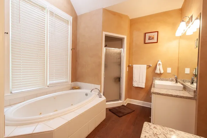 Indulge in a tranquil retreat featuring a deep soaking tub, a separate shower, and a vanity with abundant counter space.