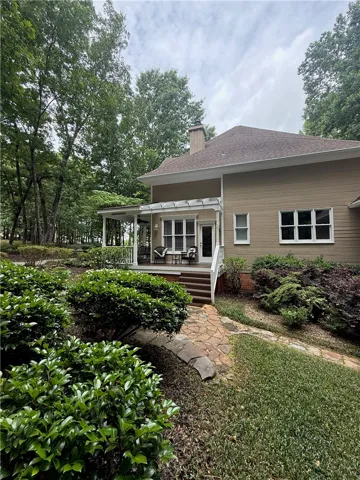 A private deck provides an inviting outdoor retreat amidst lush landscaping.
