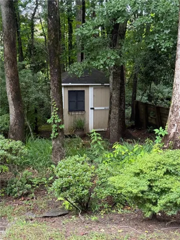 A charming garden shed nestled amongst lush trees, providing a functional and natural accent.