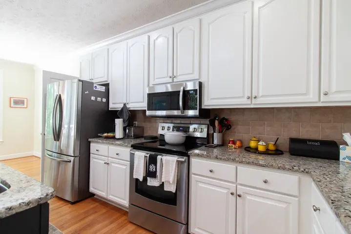 Well-equipped culinary space featuring granite counters, sleek appliances, and abundant cabinet storage.