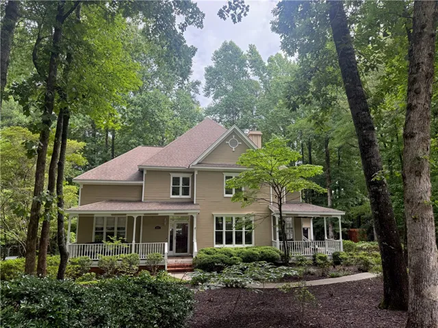 Nestled among mature trees, this inviting residence boasts a welcoming wrap-around porch.