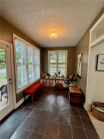 A well-lit sunroom with ample windows creates an inviting space for relaxation or activity.