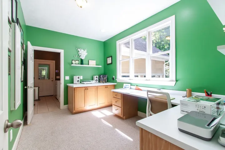 A dedicated office space features generous built-in countertops and ample natural light from an oversized window.