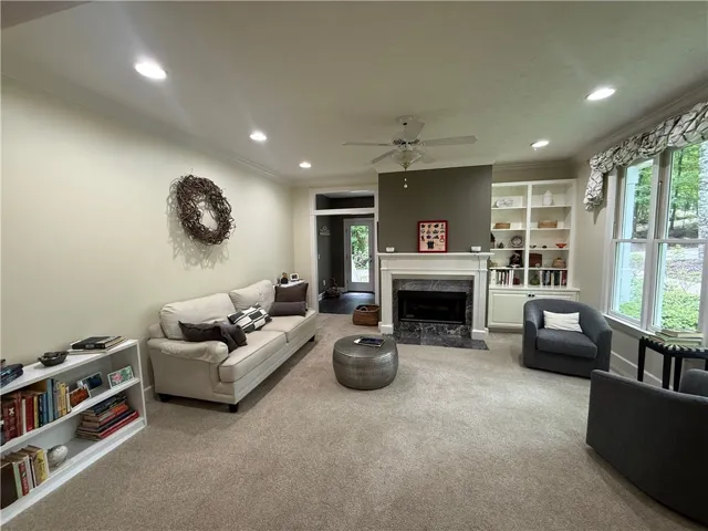 A comforting living area with a fireplace with gas logs and large windows provides a welcoming retreat.