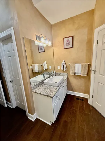 A refined bathroom featuring a contemporary vessel sink and granite counters.