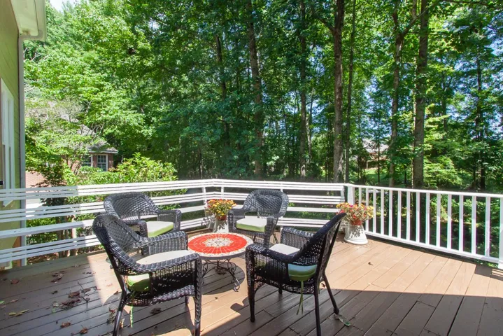 A spacious outdoor deck offers a serene, tree-lined retreat for relaxation.
