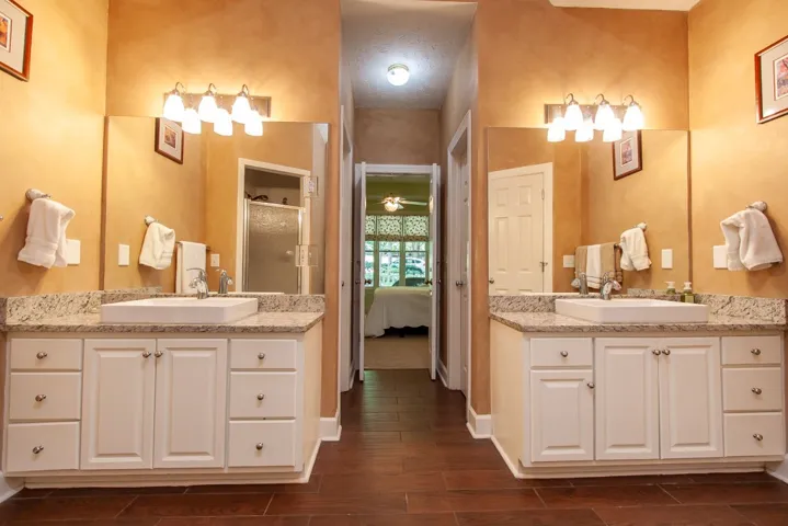 Dual vanities with granite counters provide ample space in this well-appointed primary bathroom.