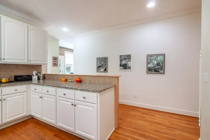 A well-lit kitchen with sleek cabinetry and natural wood flooring.