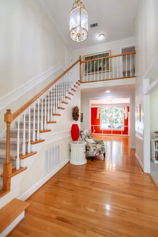 A grand two-story entryway welcomes with gleaming hardwood floors and a striking staircase.