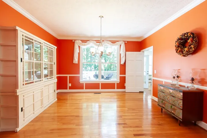 Hardwood floors gleam beneath crown molding in this inviting dining space.