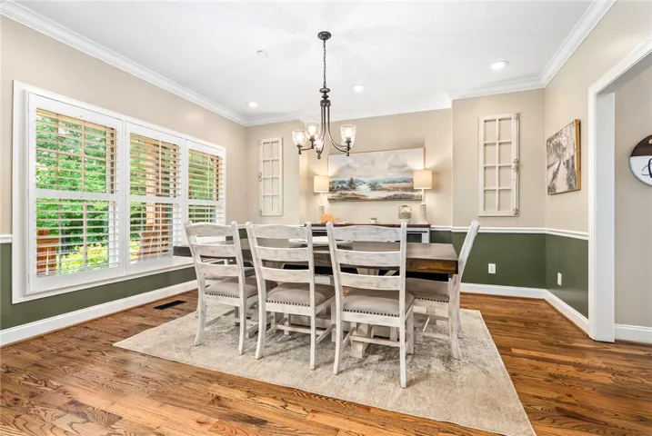 Elegant crown molding and rich hardwood floors define this inviting dining area.