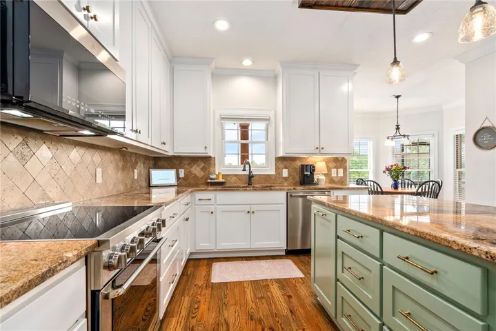 A well-appointed kitchen showcasing rich hardwood floors and premium countertops, perfect for culinary endeavors.