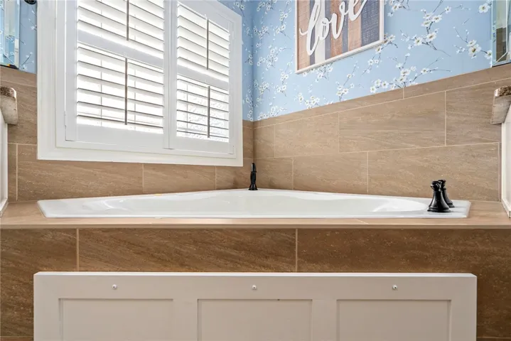 An inviting soaking tub nestled into tiled surroundings creates a tranquil retreat.