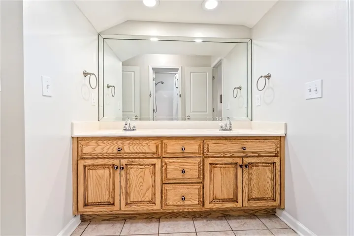 Double vanity with ample storage and a large mirror defines this functional primary bathroom.