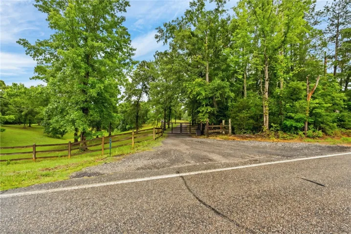 Secure gated entry welcomes you to this verdant, tree-lined property.