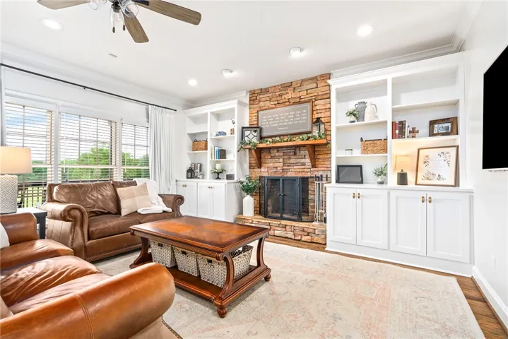 A comforting living area with a stone fireplace and built-in shelving, perfect for relaxing evenings.