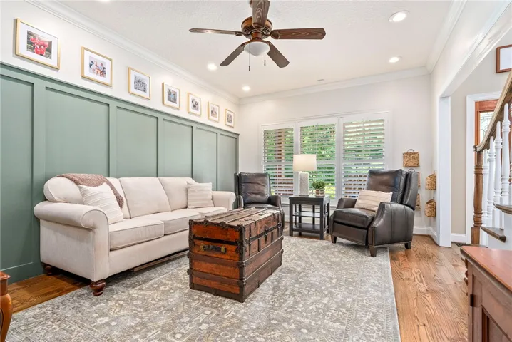 Board and batten accent wall frames a comfortable living area with gleaming wood floors.