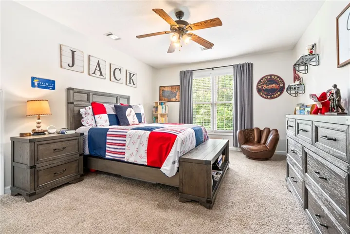 Well-appointed bedroom showcases soft carpeting and a window with natural light.