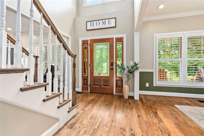 A grand entrance welcomes with hardwood floors and an impressive stained-glass front door.