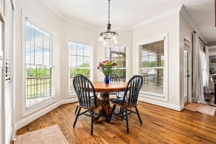 A charming dining nook boasts hardwood floors and ample natural light from surrounding windows.