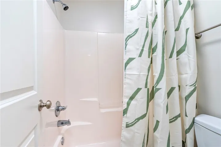 A pristine shower-over-tub combination offers a refreshing retreat within the bathroom.