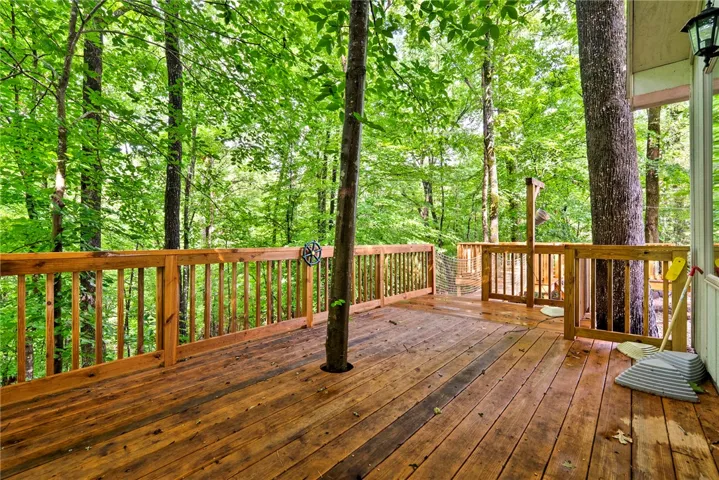 A spacious wooden deck provides a serene outdoor living area, perfectly integrated with the surrounding forest canopy.