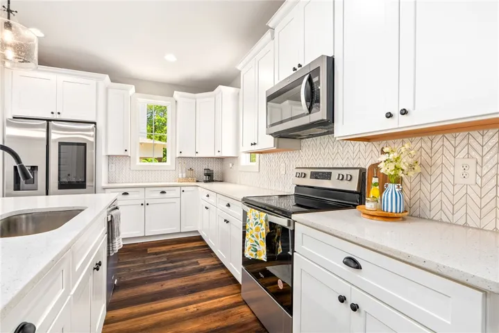 Ample cabinetry, quartz countertops and Whirlpool appliances make this kitchen both functional and stylish.