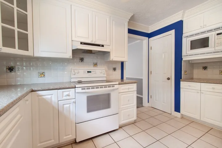 Ample solid surface countertops along with decorative tile backsplash.