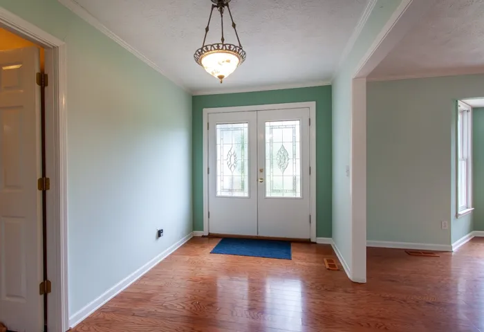 Elegant leaded glass entry doors welcome you into a spacious foyer with gleaming hardwood floors.