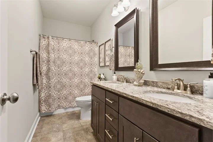 Granite counters and double vanity sinks provide functionality and style in this well-appointed bathroom.