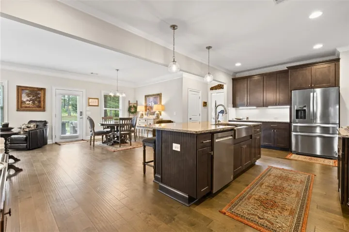 A grand, open-concept living space with sleek hardwood flooring and a functional kitchen island.