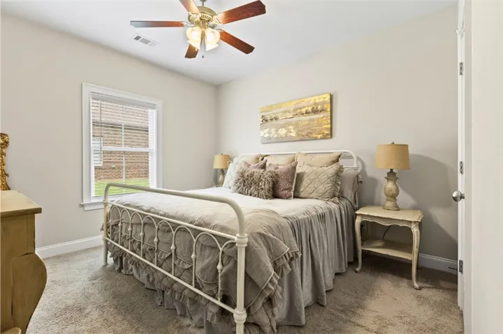 A comforting bedroom space, featuring a ceiling fan and soft carpet, creates a tranquil escape.