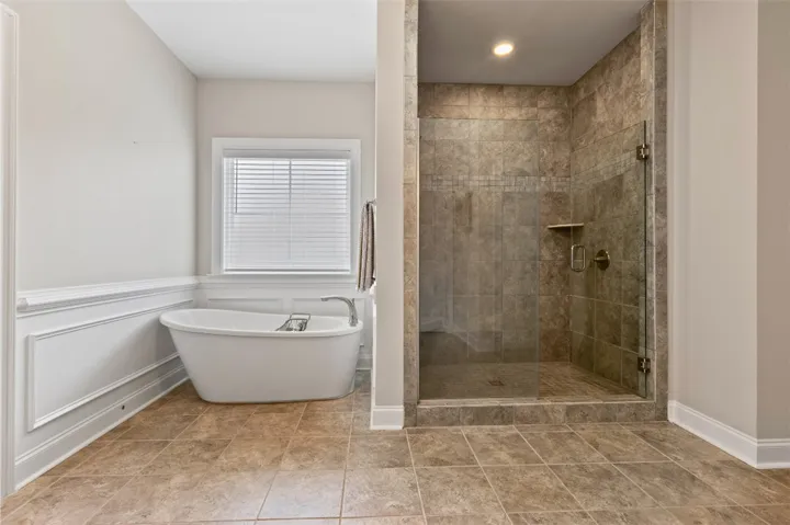 Indulge in a tranquil bathing experience with a freestanding soaking tub and an adjacent walk-in shower.