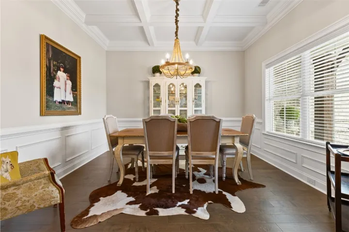 Ornate ceiling molding and wainscoting frame this elegant dining area.