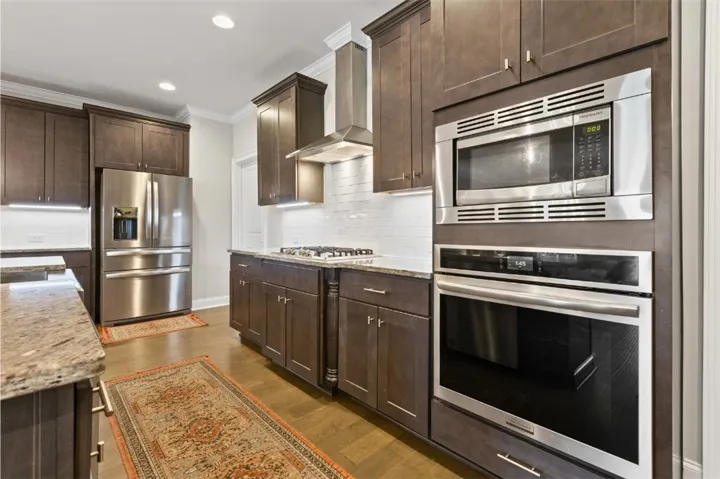 A well-appointed kitchen showcasing contemporary cabinetry, gleaming stainless steel appliances, and polished stone countertops.