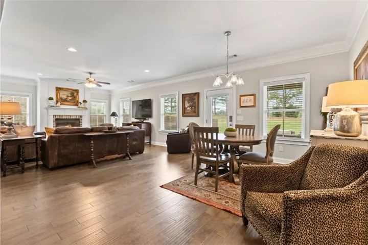 Hardwood floors flow through this welcoming living space, seamlessly connecting to a dining area and offering abundant natural light.