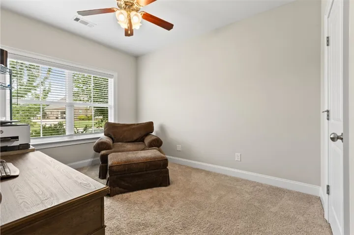 A quiet retreat with a window overlooking the neighborhood and a practical ceiling fan.